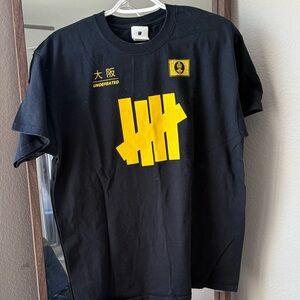 UNDEFEATED Black T-Shirt with Yellow Graphic